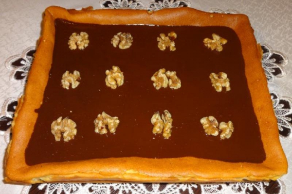 Sernik waniliowy z orzechami w polewie czekoladowej.