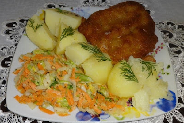 Kotlet schabowy, ziemniaki i surówka colesław.
