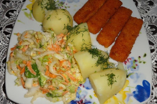 Paluszki rybne, ziemniaki i surówka.