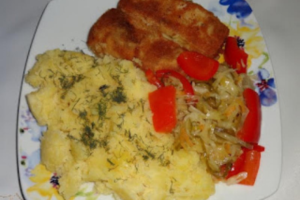 Smażona ryba morska, ziemniaki i sałatka z warzyw.