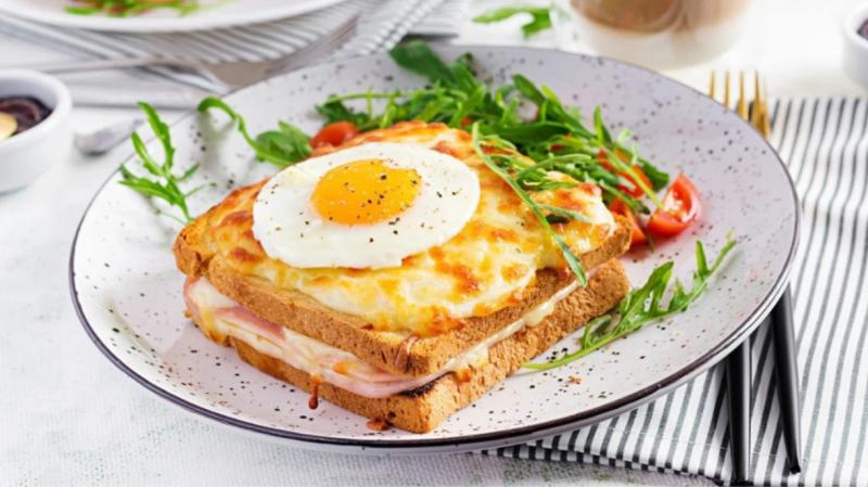 Croque Madame: chrupiący francuski tost z beszamelem, dojrzewającym serem, plastrem szynki i jakiem sadzonym