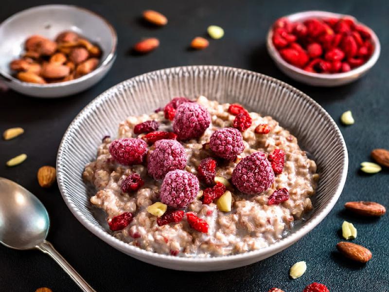 Owsianka z mrożonymi malinami, jagodami goji, orzechami laskowymi i czekoladą / Oatmeal with frozen raspberries, goji, hazelnuts and chocolate