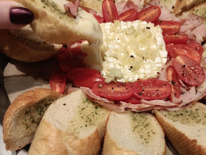 Bagietka czosnkowa zapiekana z serem camembert, szynką i pomidorkami