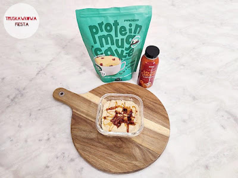 Ciasto proteinowe w kubku z wanilią, kawałkami czekolady i polewą karmelową